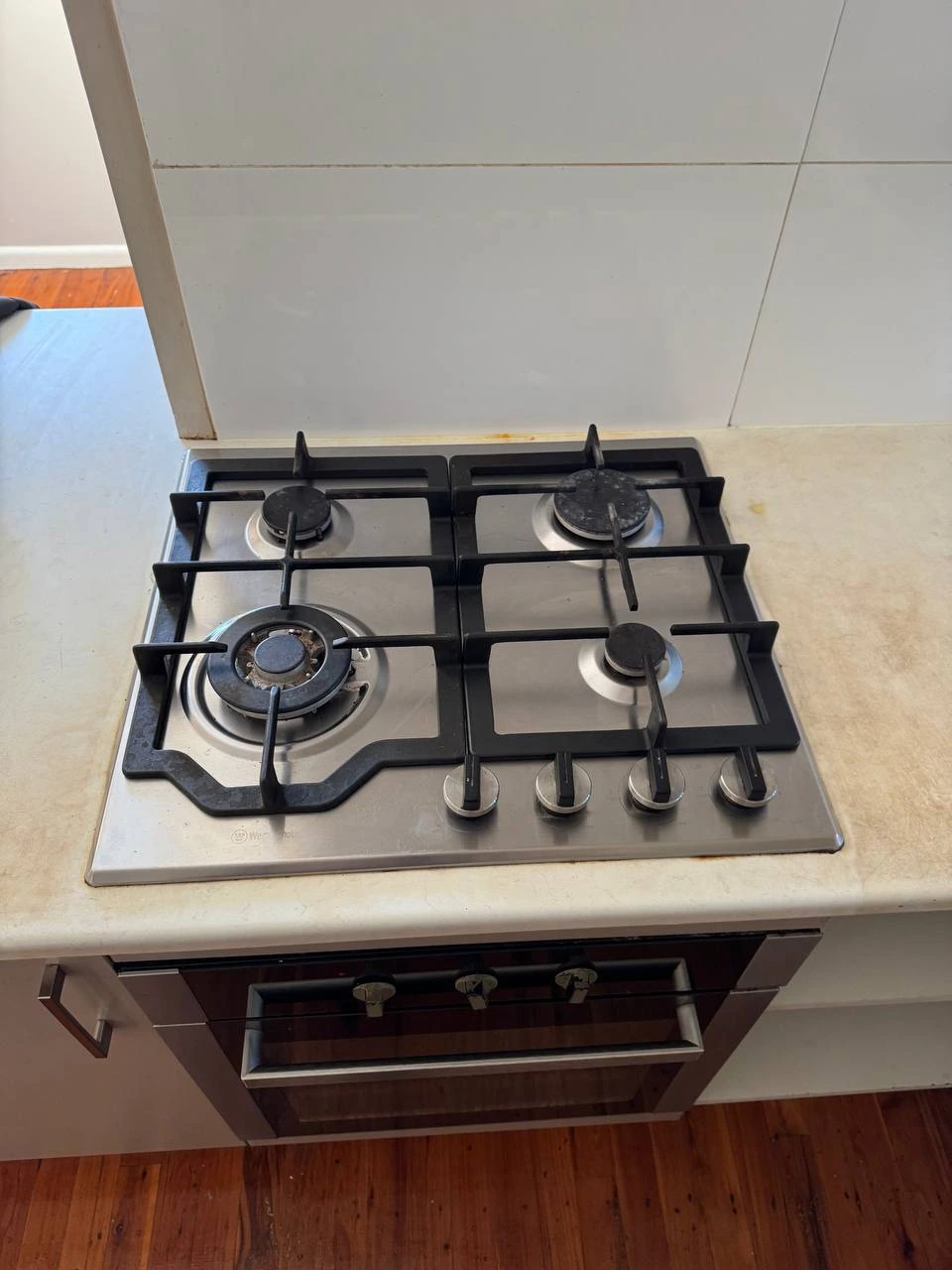 Sparkling clean white gas cooktop after professional bond clean — after